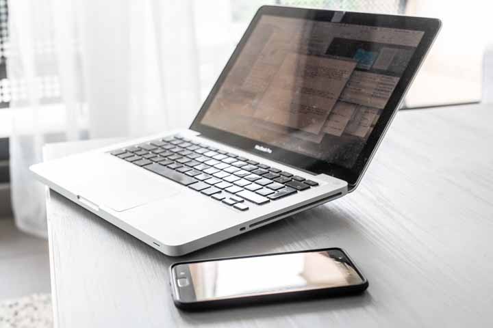 Macbook Pro laptop with black phone